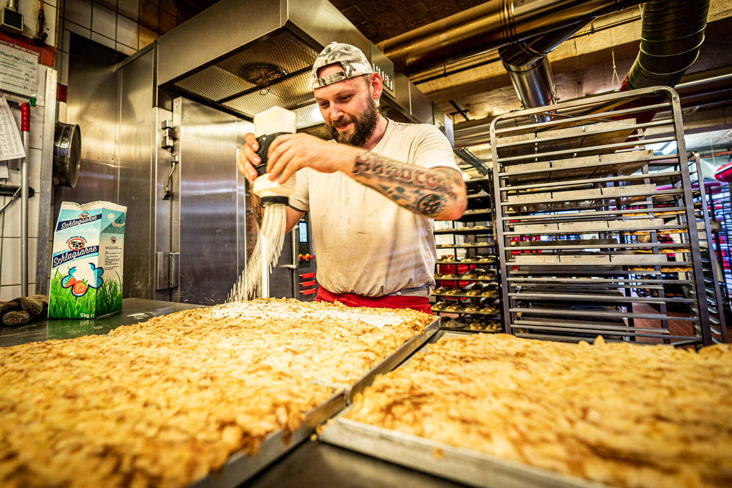 Butterkuchen wird mit flüssiger Sahne beträufelt.