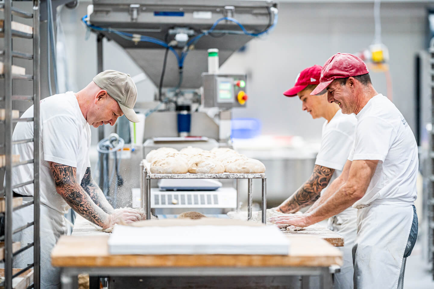Bäcker kneten gemeinsam Teig