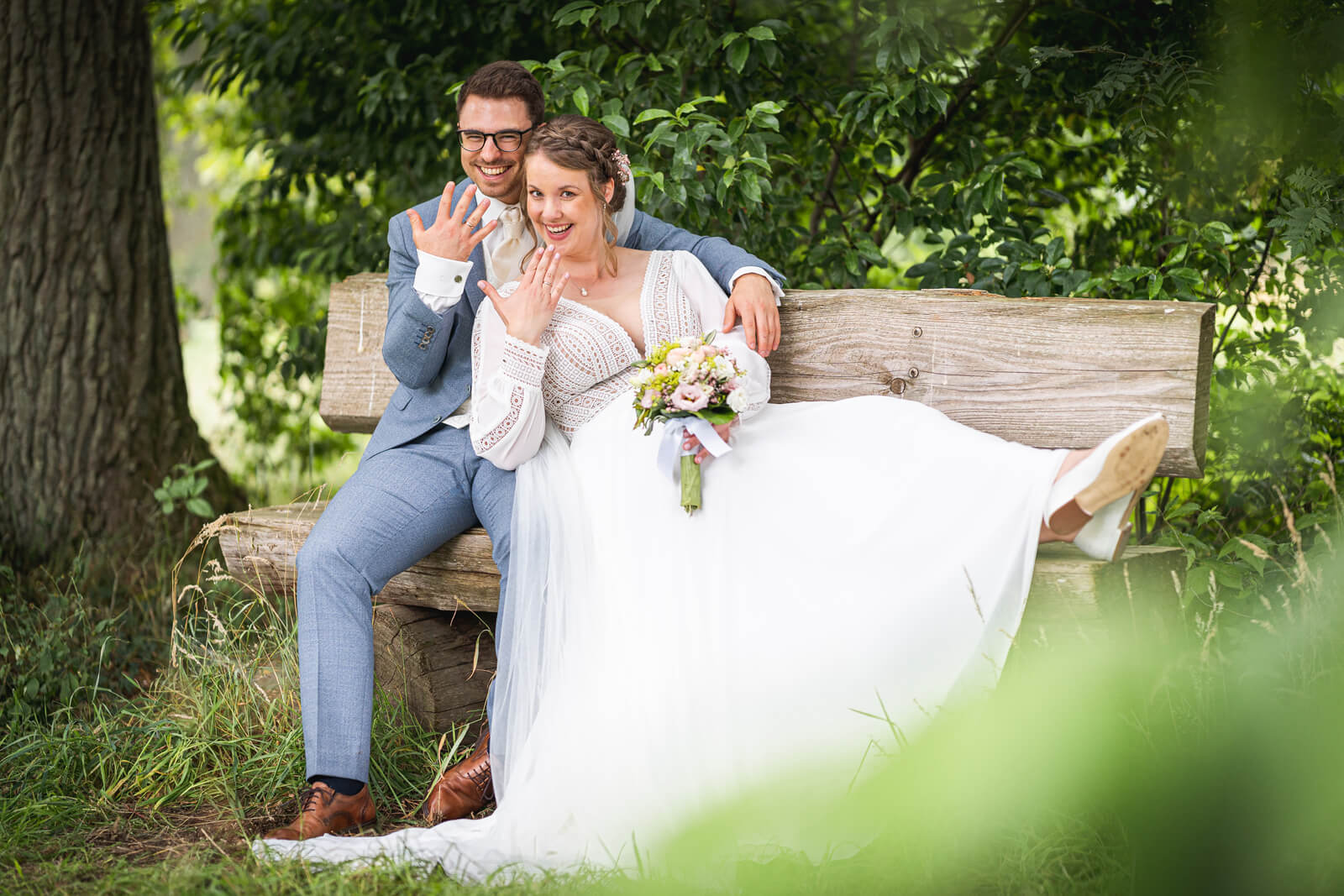 Witziges Hochzeitsfoto: Brautpaar zeigt die Trauringe.