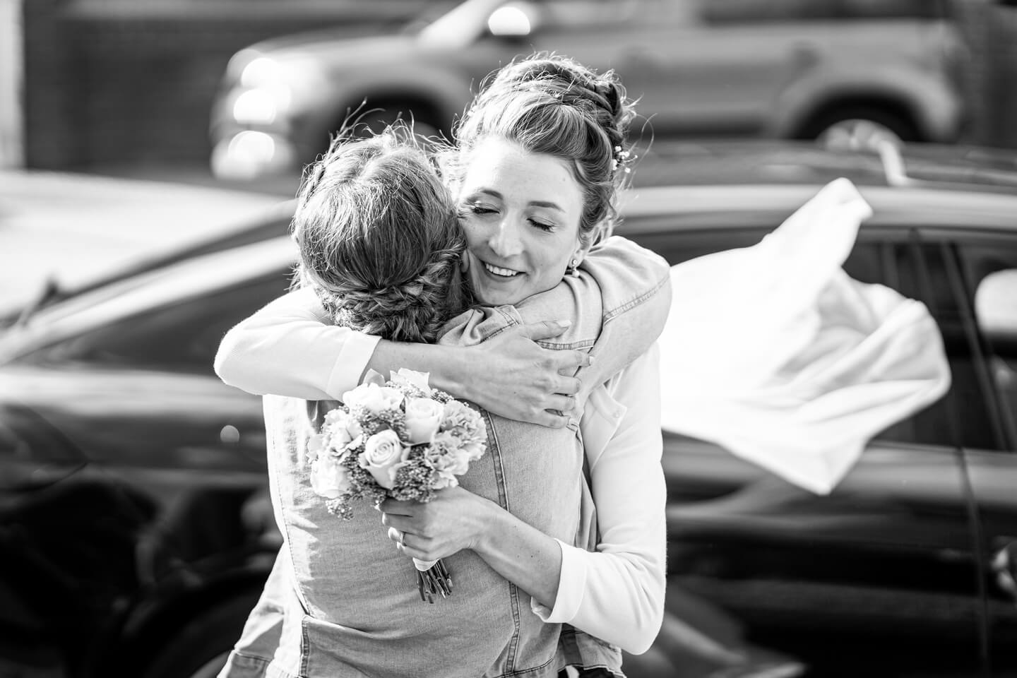 Braut drückt ihre Trauzeugin ganz fest.