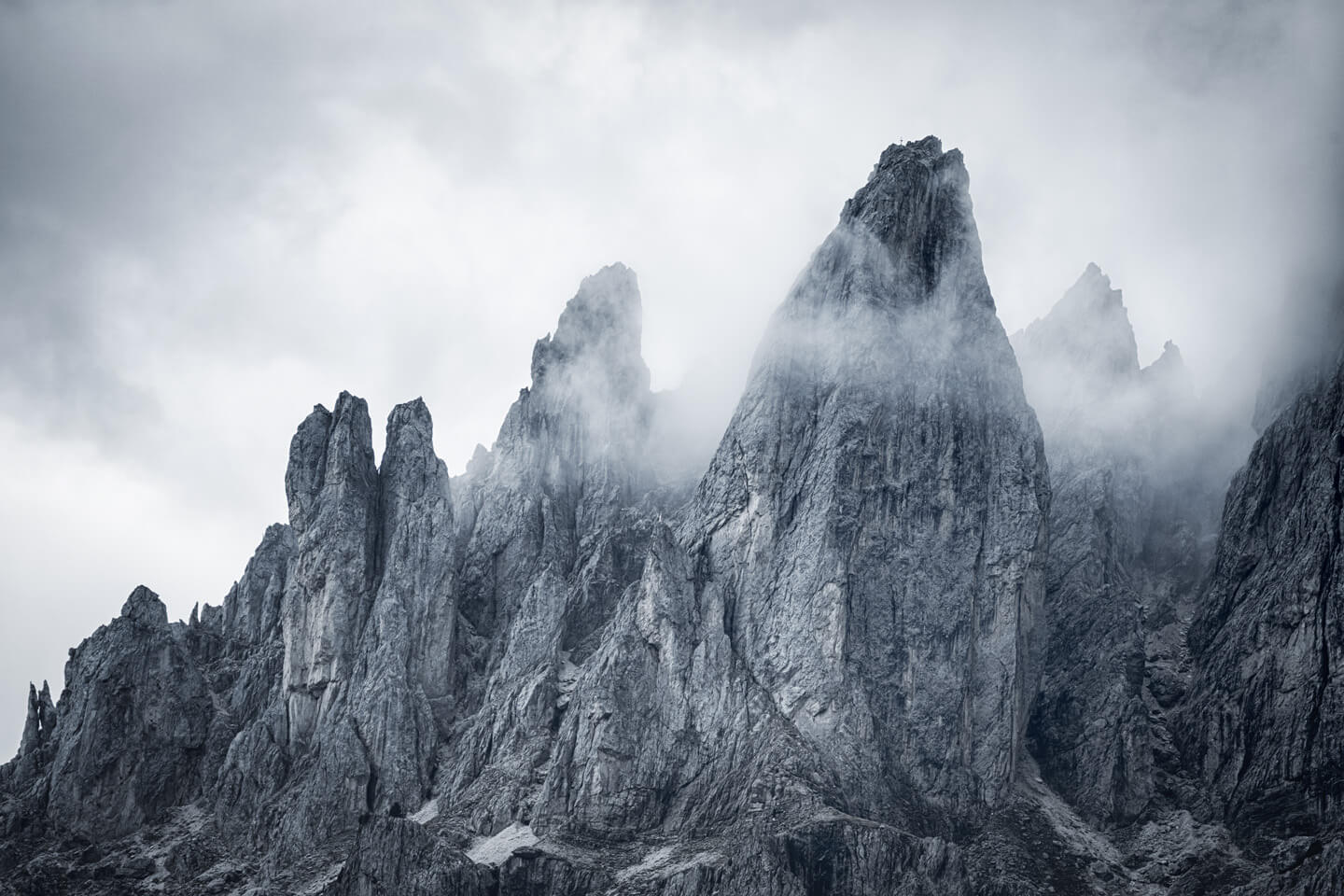 Gipfelkreuz in dramatischer Berglandschaft