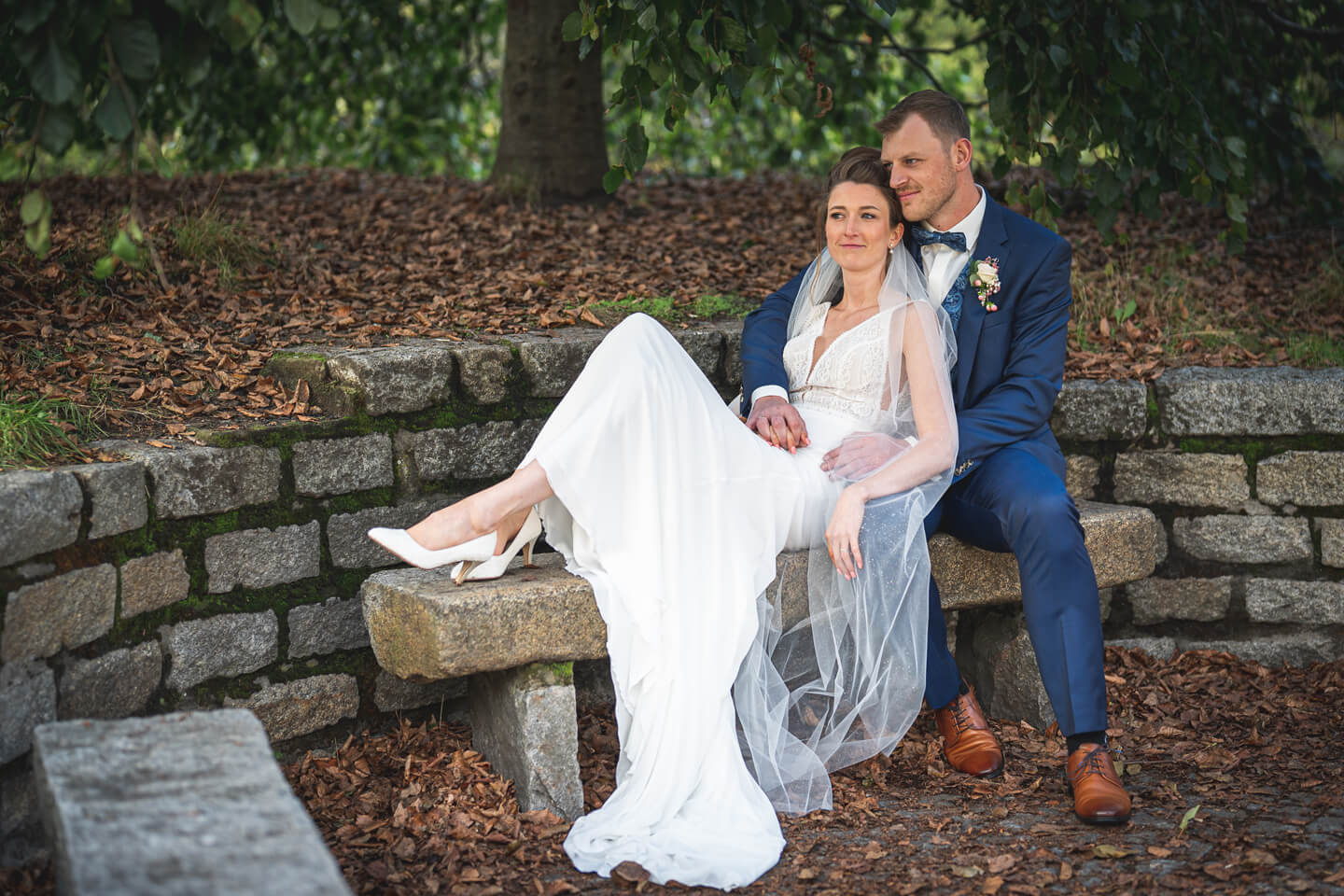 Brautpaar auf einer Steinmauer