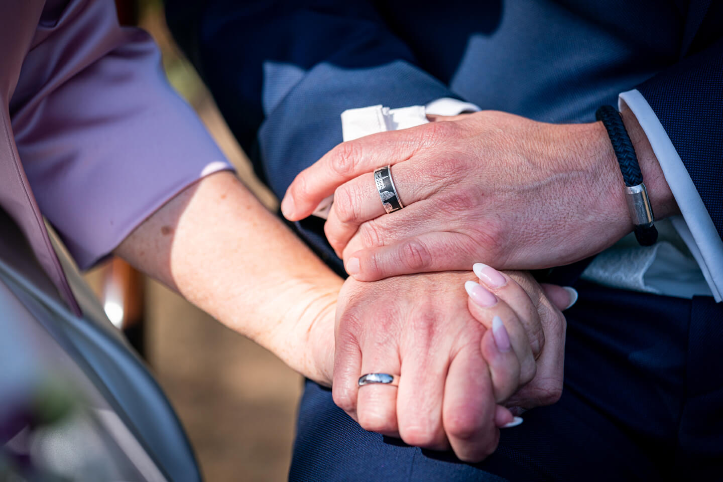 Hochzeitspaar hält sich die Hände.