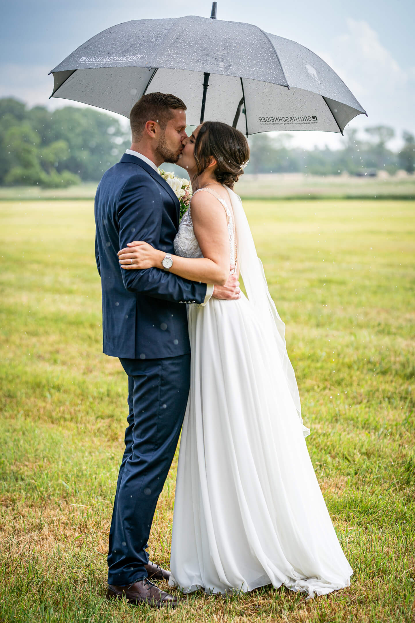 Küsse im Regen während des First Look Shootings